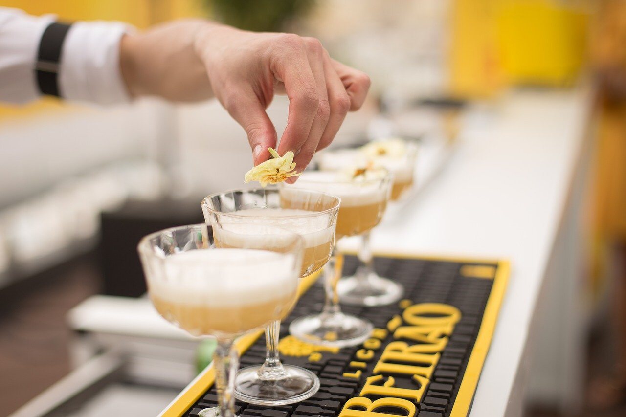 A row of cocktails being finished at the bar